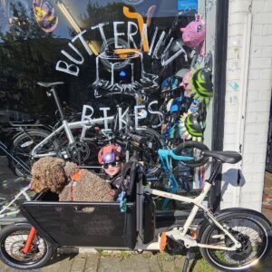 Muli cargo bike outside Butternut Bikes in Crouch End with Sprocket the shop dog in the front basket