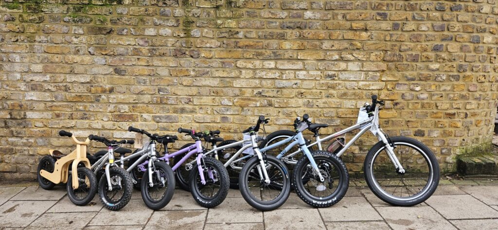 Early Rider kids' bikes lined up outside Butternut Bikes in Crouch End, from a balance bike up to a 20 inch