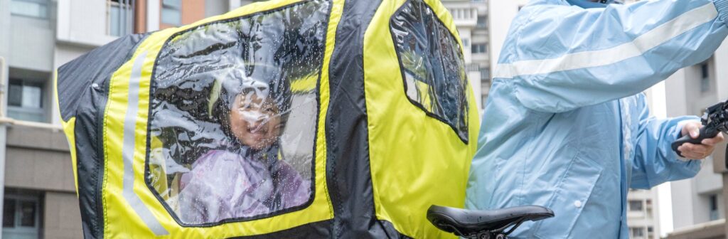 A child dry under the Tern Rain Shield on a Tern GSD in the rain
